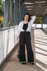 Confident Young Woman in Professional Attire on Modern Urban Walkway