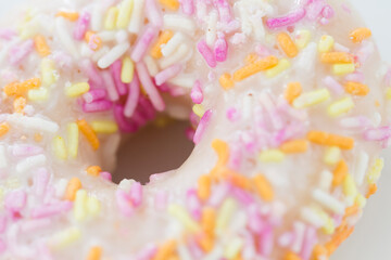 Close up on a donut resting on white background.