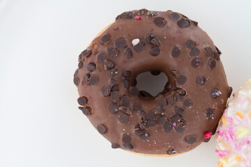 Close up on a donut resting on white background.