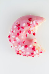 Close up on a donut resting on white background.