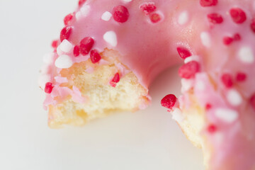 Close up on a donut resting on white background.