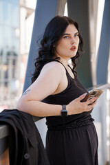 Confident Young Woman at Urban Balcony with Smartphone