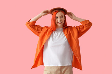 Beautiful young happy woman in beret on pink background