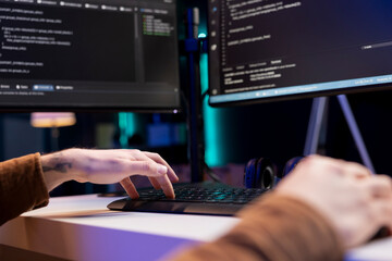 Developer typing code on computer to futureproof company network from downtimes and unexpected...