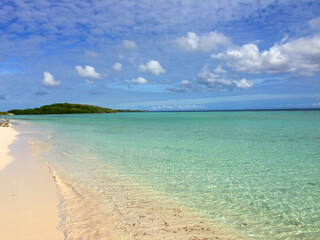 on the shores of the Caribbean Sea with crystal clear waters and white sands with rocks and blue sky