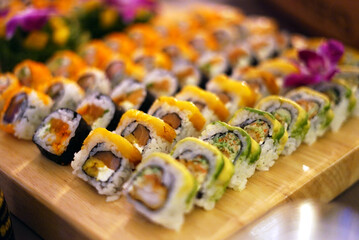 variety of sushi rolls arranged on a bamboo board