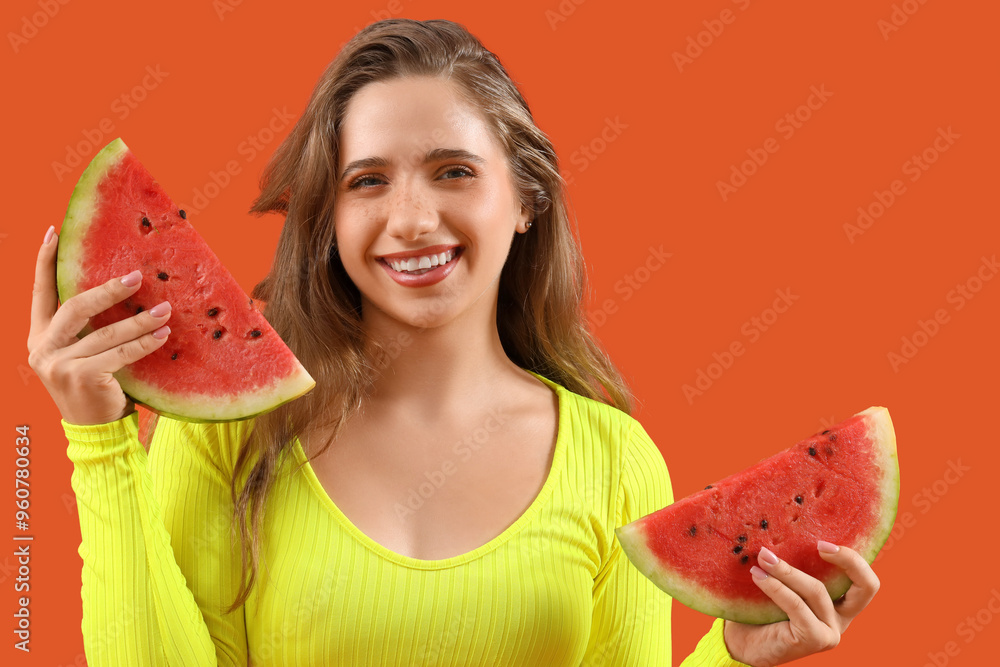 Wall mural beautiful young happy woman with slices of fresh watermelon on orange background