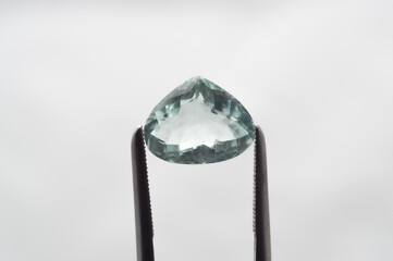 Exquisite Aquamarine Gem Held by Precision Tweezers Against Soft Focus Background