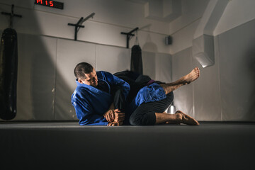 BJJ Brazilian Jiu jitsu Athlete fighters training sparing technique at the academy fight in gi kimono