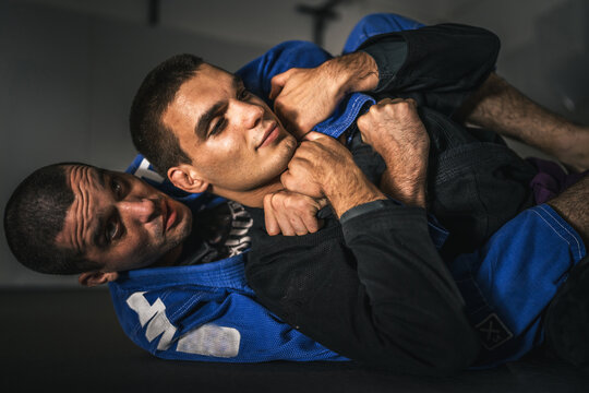BJJ Brazilian Jiu jitsu Athlete fighters training sparing technique at the academy fight in gi kimono