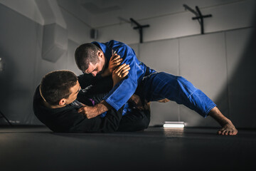 BJJ Brazilian Jiu jitsu Athlete fighters training sparing technique at the academy fight in gi kimono