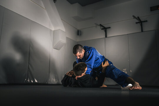 BJJ Brazilian Jiu jitsu Athlete fighters training sparing technique at the academy fight in gi kimono