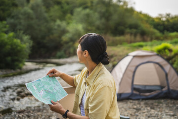 mature japanese woman sit and hold map look for road and next location