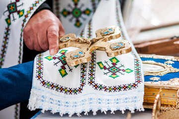 Intricate Unity: Traditional Ceremony with Ornate Cross and Embroidered Textile