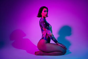 Photo of seductive sexy lady wear print colorful body sitting knees isolated purple color background