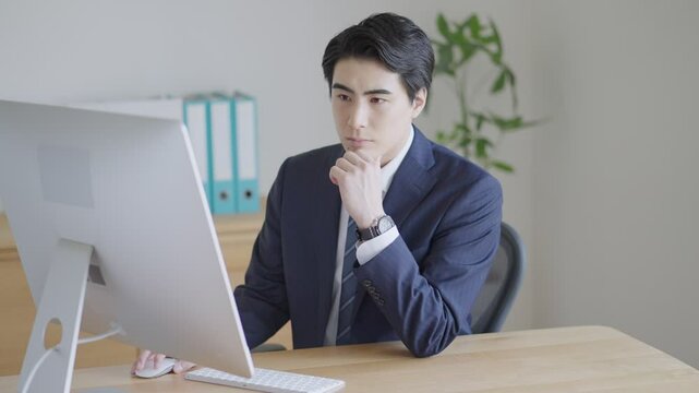 デスクトップパソコンを使って働くビジネスマン