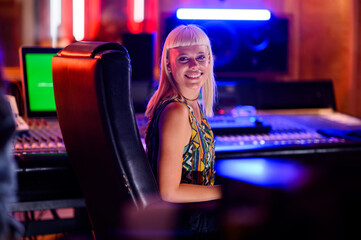 Portrait of a woman sound engineer working with a music band in her studio