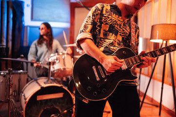 Fototapeta premium Guitar player playing while recording or practicing in a recording studio