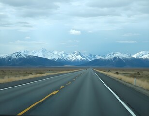 Naklejka premium Panoramic shot of a straight asphalt highway cutting through a natural landscape featuring snow-covered peaks, green meadows, and a dramatic cloud-filled sky