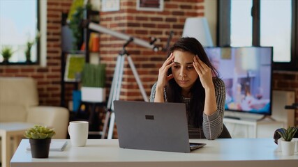 Stressed overworked indian employee struggling to concentrate while working from home, hurting from...