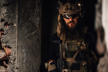 Portrait of air soft fighter hiding in ambush in ruins.