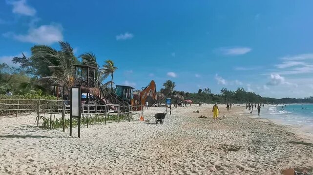 Tropical Caribbean beach people fun thatched roof palapa in Mexico.