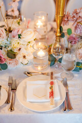 Beautiful table in a restaurant decorated with flowers and candles. Plate and cutlery with chopsticks. Beautifully set table waiting for guests in a restaurant