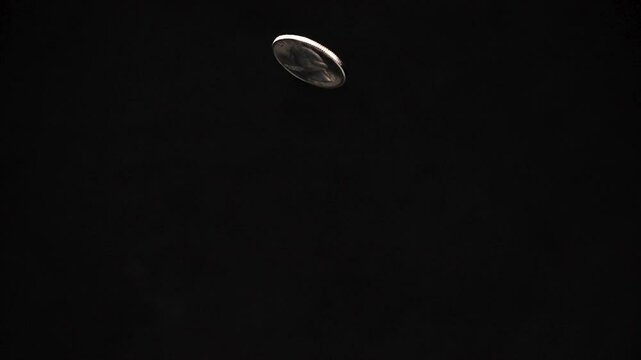 US Quarter Coin Rising into Frame and Falling Back Down