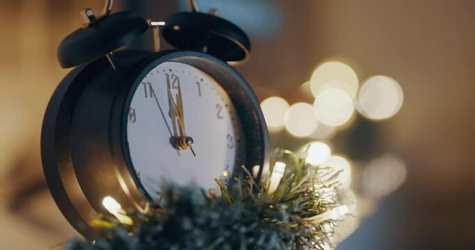 Christmas eve night with  clock face showing midnight 12 o'clock and siting on a Christmas tree. The clock is set to the time of 00:00