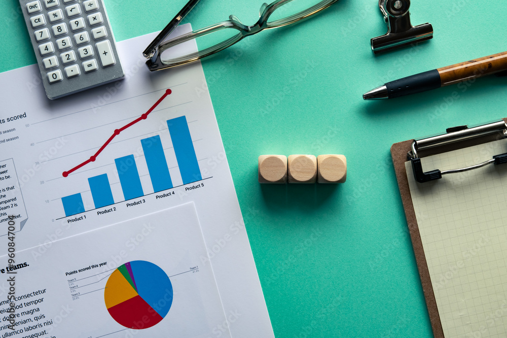 Poster desk with three wooden cubes in a row. together with paper and stationery with graphs printed on the