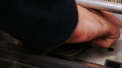 Mechanic using a specialized tool for tightening a bolt on the underside of a vehicle seat, ensuring proper installation for enhanced safety and functionality in automotive repair