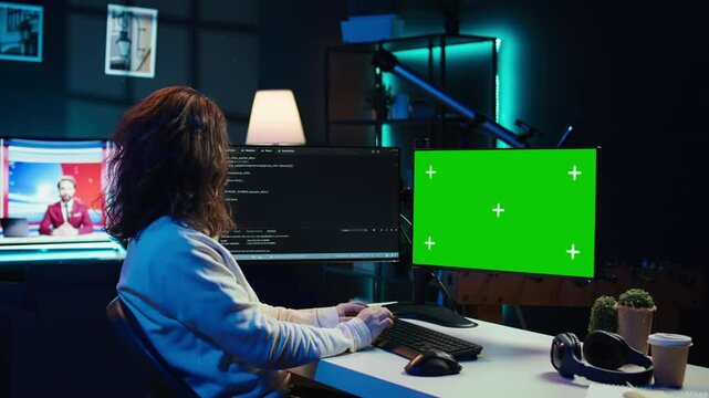 Developer doing software debugging on green screen PC at home, checking lines of code displayed on monitors. IT professional in living room fixing coding problems on mockup computer, camera B