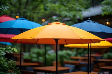 A cozy outdoor cafe scene adorned with colorful umbrellas in a lush green setting. The foreground features a vibrant orange umbrella prominently, surrounded by other umbrellas in deep blue