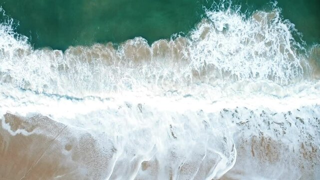 Vista a&eacute;rea de drone voando sobre uma bela praia com vista para as ondas do oceano e &aacute;gua batendo na praia de areia do &acirc;ngulo superior