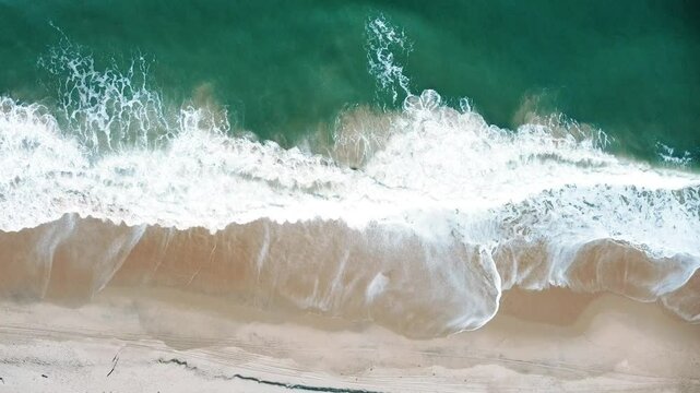 Vista a&eacute;rea de drone voando sobre uma bela praia com vista para as ondas do oceano e &aacute;gua batendo na praia de areia do &acirc;ngulo superior