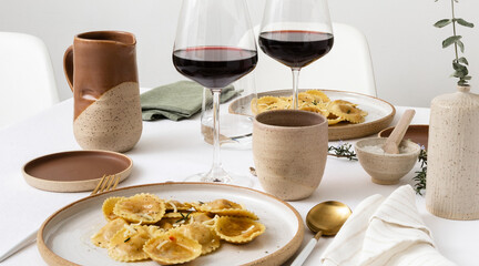 Elegant table, no plastic, ceramic tableware, wine in glasses and white linen, romantic diner