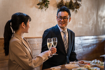 居酒屋で忘年会・新年会・飲み会・宴会をする仕事仲間・同僚・上司部下の男女
