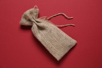 One burlap sack on red background, top view