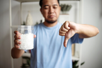 Man Holding White Sugar Cubes While Giving Thumb Down. No Sugar Concept.