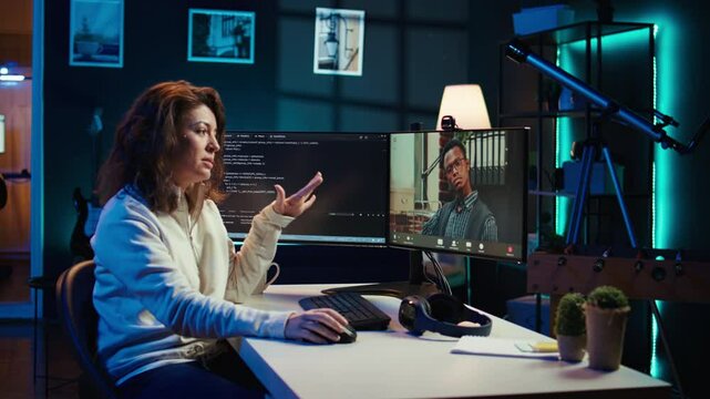 Woman doing software debugging helped by coworker in videocall, checking errors in lines of code. Programmer working from home fixing coding mistakes, assisted by colleague in teleconference, camera B