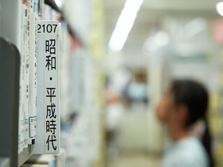図書館で本を探す学生の姿と本棚の検索目次