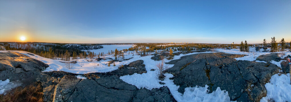 Yellowknife's Frame Lake Trail System overlooking JackFish Lake, Winter sunset in April over frozen lake and rocky landscape, Northwest Territories Hiking