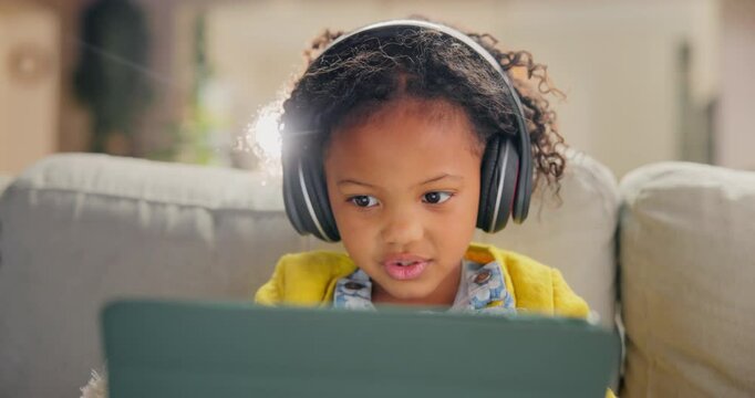 Girl, child and tablet for learning in home, online education and listening to podcast for study. Female person, kid and playing games in living room for mind development, happy song and streaming