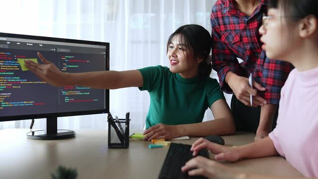 Slow motion back end software developer engineer for computer programming working together on debugging writing computing code, solving complex algorithms display on monitor in office. Burgeoning