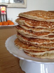Large Stack of Pancakes Side View With Oranges in Background