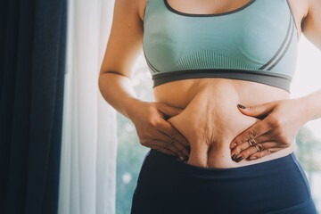 fat woman, fat belly, chubby, obese woman hand holding excessive belly fat with measure tape, woman diet lifestyle concept