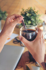 Vertical Close up hands of woman sitting office desk holding sweet coffee cup relax and enjoy with happy time. Vertical Horizon Hot coffee mug in hand. Woman hand holding coffee cup relax at office