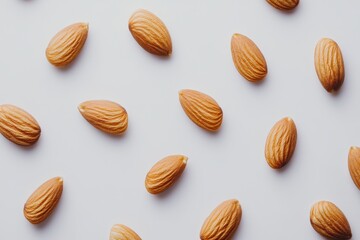 A collection of almonds scattered on a white surface.