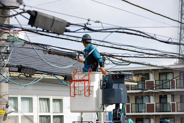 住宅街の電線を修理する作業員