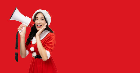 Joyful woman in a festive Santa Claus costume holding a megaphone, standing against a vibrant red background. Image conveys excitement and is perfect for holiday-themed announcements or promotions